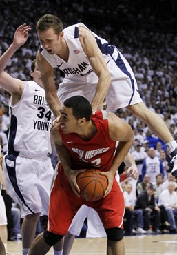 BYU guard Jackson Emery, top, falls on New Mexico forward Drew Gordon, bottom, as forward Noah Hartsock (34) also defends during the second half of an...