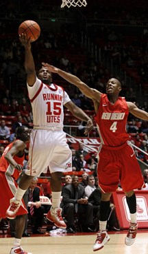 New Mexico forward Chad Adams defends Utah guard Josh Watkins.