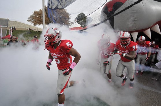 Kasey Carrier leads the Lobos onto the field.