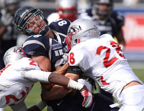 New Mexico defenders Destry Berry, left, and Bubba Forrest (28) tackle Nevada tight end Kolby Arendse, center, in the first quarter. (AP...