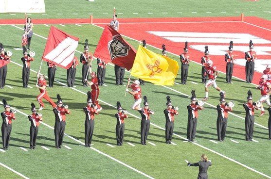 New Mexico Man David Anaya carries the state flag out onto the field at the start of the game.