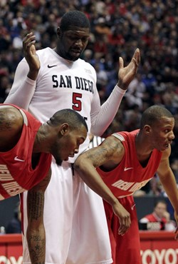 San Diego State's Brian Carlwell, center, reacts as New Mexico's A.J. Hardeman, left, and Chad Adams, right, position themselves for a free throw in...