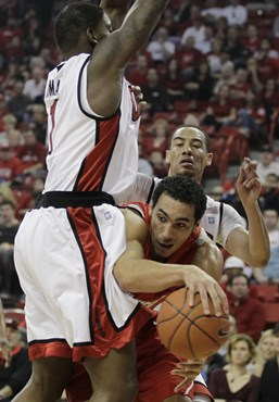 New Mexico's Drew Gordon passes the ball off against UNLV's Quintrell Thomas and Chace Stanback.