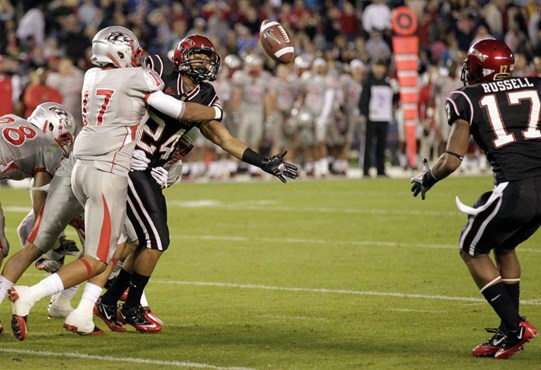 San Diego State wide receiver Colin Lockett (24) tries to pitch the ball to teammate Marcus Russell, right, as New Mexico defensive back Freddy Young,...