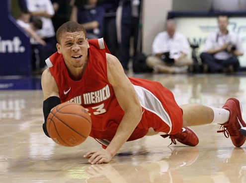 New Mexico guard Phillip McDonald (23) attempts to pass the ball after falling to the court during the second half of an NCAA college basketball game...