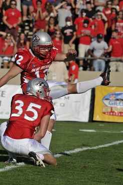 Ben Skaer holds the ball as James Aho kicks an extra point for the Lobos