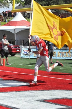 Sophomore Jeric Magnant carries out the New Mexico state flag as the Lobos take the field. Magnant was designated the opening week's New Mexico Man by...