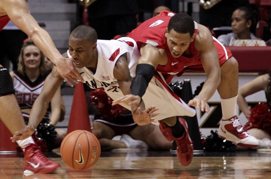 San Diego State's D.J. Gay, left, battles New Mexico's Dairese Gary for a loose ball in the second half  of an NCAA college basketball game Wednesday,...