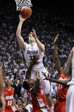 BYU guard Jimmer Fredette (32) attempts to score over New Mexico guard Jamal Fenton (13) during the first half of an NCAA college basketball game in...